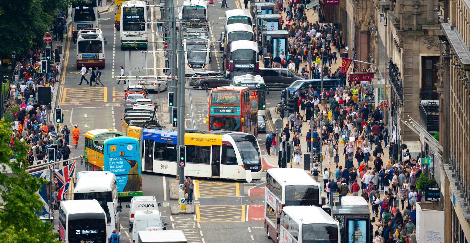 Heavy public transport traffic and pedestrians on Princes Street in Edinburgh, Scotland, UK.