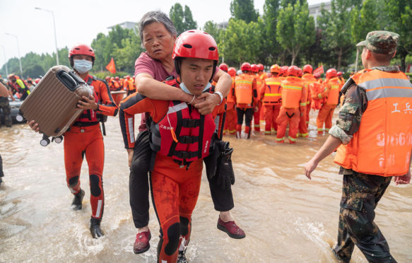 People are evacuated after heavy downpours in Zhengzhou, Henan, China, on 22 July 2021. Credit: Xinhua / Alamy Stock Photo. 2G8R652