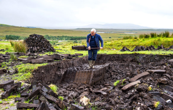 Blocks of peat being cut in Connemara National Park, Republic of Ireland. Credit: robertharding / Alamy Stock Photo.