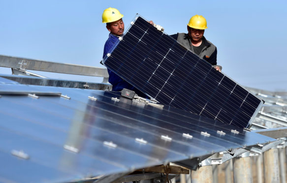 Staff-install-solar-panels-at-Xinyi-Photovoltaic-Power-Plant-in-Binhai-District-of-Tianjin,-North-China